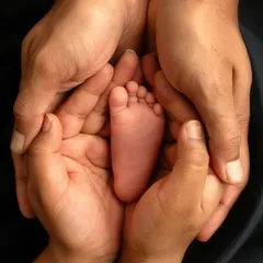 A slightly different composition, showing the beautiful texture and color of the baby's skin against their parents' hands. These are the details you'll want to remember forever.