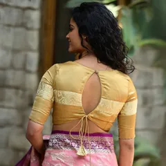 This golden blouse features a keyhole back with a tie-up tassel, combining a classic color with a modern design detail.