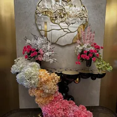 A stunning cascading floral arrangement flowing down from a console table. We used an ombre effect with flowers transitioning from white and peach to pink and deep magenta, creating a waterfall of color.
