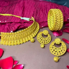 This meticulously handcrafted gold jewellery set embodies tradition and beauty. The intricate choker, regal bangle, and matching earrings tell a story of heritage and artistry.