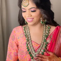 This happy client chose a long, multi-layered emerald green bead necklace with a matching maang tikka for her pre-wedding function.