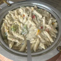 Creamy, cheesy, and loaded with vegetables, my White Sauce Pasta is a favorite at corporate events and school functions. I prepare it in bulk without compromising on taste or quality, serving it hot from elegant copper-bottomed warmers.