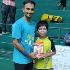 A coach awarding a prize to a young winner at our internal tournament. These events are a great way to introduce junior players to a competitive format.