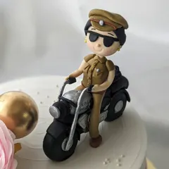 A close-up of the handcrafted figurine from the police inspector cake. I pay close attention to details like the uniform, sunglasses, and motorcycle to create a realistic and personalized cake topper.