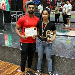 Our golden girl, Priyanka, posing with her coach after her win. This picture captures the partnership between our athletes and trainers that is essential for success in powerlifting.