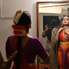A student gets ready in the green room, catching a final glimpse in the mirror. The moments before going on stage are filled with a unique, focused energy.