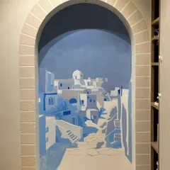 The mural in progress. Here, I'm blocking in the iconic blue and white architecture of Santorini, establishing the shadows and forms that will create a sense of depth.