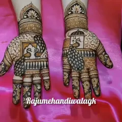 A beautiful Teej mehendi featuring peacocks inside a 'jharokha' (window). The details on the peacock feathers and the floral patterns on the fingers are very fine.