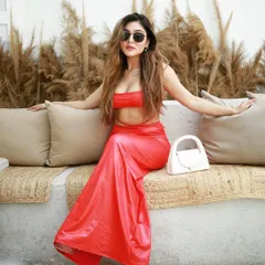 A full-length shot of a model in a vibrant red co-ord set, posing confidently in a chic, sunlit cafe. This image is perfect for influencers and brands looking for stylish, commercial-quality content.