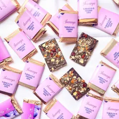 Celebrating a special birthday with custom chocolate bars. These mini chocolates, wrapped in personalized pink sleeves for Shanaya's party, are perfect as party favors.