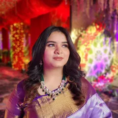 A vivacious bridesmaid looking stunning in a purple saree with her hair in soft waves and makeup that complements her vibrant personality.