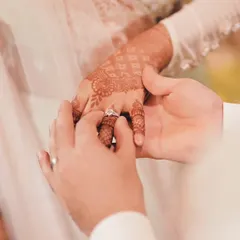 The moment the engagement ring is placed on her finger, a macro shot that highlights the ring and her beautiful henna.