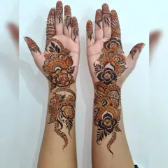 For a modern and bold statement, I love creating Arabic-style henna. This design features prominent floral vines that flow elegantly along the hands, leaving open space to make the pattern pop.