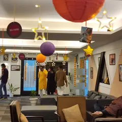 To carry the Bollywood theme throughout the office, I used a mix of colorful paper lanterns, star-shaped lights, and hanging circular signs with movie-related words. This view shows the decorated lounge and entrance area, creating an inviting party atmosphere.