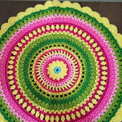The Viola mandala laid flat, showing its perfect circular shape and the joyful color combination. It makes a wonderful doily or table centerpiece.