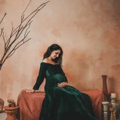 A moment of quiet reflection. The rich texture of this green velvet gown contrasts beautifully with the warm, rustic tones of the terracotta backdrop and props.