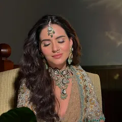 A moment of quiet contemplation. Even with eyes closed, the makeup is striking, showcasing the seamless blending and soft contouring.