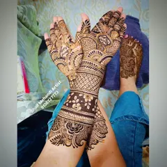 A complete bridal look, showing how the feet mehandi can be coordinated with the hand designs for a cohesive look.