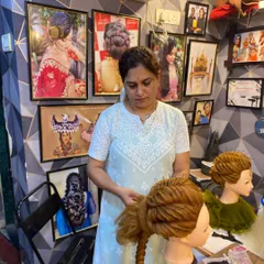 Another shot of a student perfecting her work. The background shows the inspiring environment of my salon, filled with examples of advanced hairstyling.