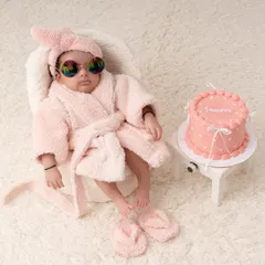 The full spa day setup for a one month milestone. Complete with a tiny cake, sunglasses, and a fluffy robe, this theme is all about fun and personality.