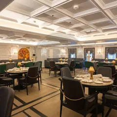 A wide view of the dining area at Begeterre. Notice how the arrangement of our custom tables and chairs creates distinct seating zones while maintaining a cohesive, regal atmosphere.
