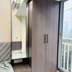 This compact wardrobe unit includes an integrated dressing table with a large mirror and drawers, making it a complete storage and grooming solution for the bedroom.
