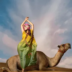 A playful and graceful pose next to the camel, showcasing the flowing silhouette of the green and yellow kaftan.
