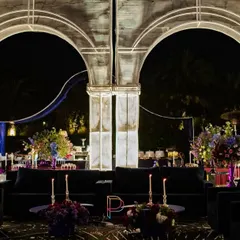 We designed these illuminated white arches to frame the lounge area, creating a futuristic, architectural element. The dark velvet sofas and celestial-print carpet complete the cosmic vibe.