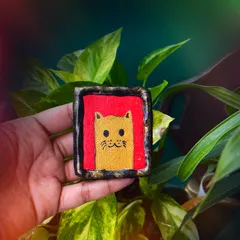 For all the cat lovers out there, this quirky, hand-painted cat magnet is sure to make you smile. The bold red background makes the illustration pop.