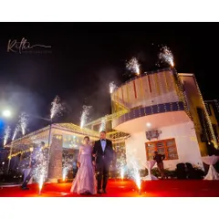 A modern couple making their entrance. The groom's classic black tuxedo provides a sharp, elegant contrast to the bride's shimmering rose gold gown, creating a timeless look for their cocktail party.