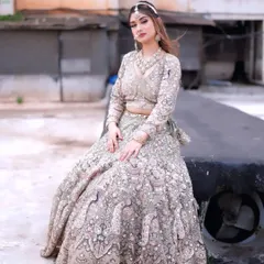 A sitting pose in the pastel green lehenga, showing the beautiful fall of the heavily embroidered skirt.