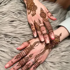 An example of a lighter, more delicate design that is perfect for wedding guests. This style features vine and floral motifs on the back of the hand, leaving parts of the skin open for a modern look.