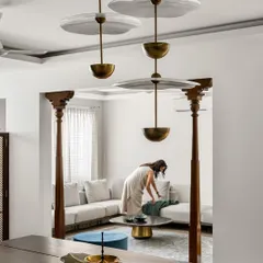 A view from the dining area into the living room, framed by two traditional wooden pillars. This is a signature element I use to demarcate space while adding a touch of South Indian architectural history.