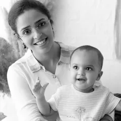 A joyful mother and baby portrait in black and white. The high-contrast look makes their happy expressions pop.