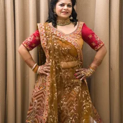 A full-length shot of the heavy bridal-style lehenga. The hands-on-hips pose is strong and classic for fashion photography.