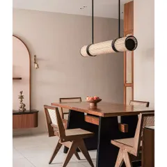 The dining space in the 'Kayu' project shows how carefully chosen furniture can define a room. The combination of a solid wood table, cane chairs, and a unique pendant light creates a harmonious and layered look without overwhelming the space.