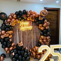 A clear, full shot of the 25th-anniversary decoration, showcasing the black and rose gold balloon arrangement with butterfly accents.