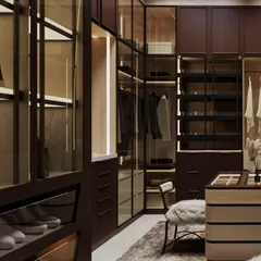 A detail of the glass-fronted wardrobes, which are internally lit to showcase the clothing and shoes. The design balances luxury with practical organization.