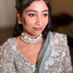 A poised and elegant portrait of Neha. This angle shows the subtle contouring and the beautiful half-up, half-down hairstyle that completes her reception look.