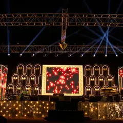 I designed this sangeet stage with a repeating arch motif, outlined with warm lights to create depth and visual interest. The central LED screen, framed in gold, served as a dynamic backdrop for the night's performances.