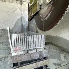 Watch my multi-blade cutting machine precisely slicing a large block of Bangalore stone into uniform slabs. This is how I ensure consistency for your projects.