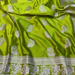 This lime green Banarasi saree is a modern take on a traditional weave. The silver rose motifs are scattered across the body, and the border features a detailed floral vine pattern.