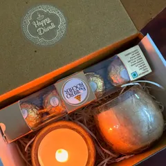 A thoughtful mini hamper for Diwali. This box contains a set of two scented candles in glass jars, Ferrero Rocher chocolates, and a Diwali message card.
