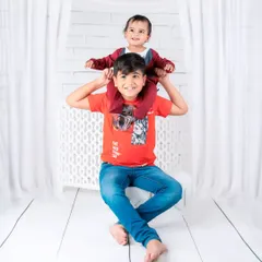 A playful moment between brothers, with the younger one enjoying a ride on his big brother's shoulders. A photo full of fun and energy.