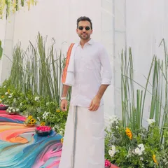 A full-length view of my South Indian attire against a colorful, modern backdrop. I ensure my look complements the event's decor and theme perfectly.