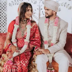 A moment of quiet connection. The couple seated together after their ceremony, sharing a look of love.