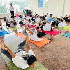 A full class of dedicated students moving together in Dhanurasana, or Bow Pose. This image captures the collective energy and focus we cultivate in our group sessions, where everyone supports each other's practice.