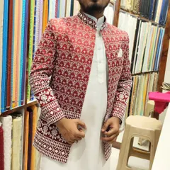 A close-up of the red and white embroidered shrug, showing the intricate geometric and floral patterns on the cuffs and body.