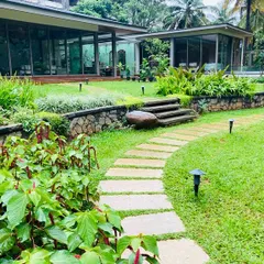 The design incorporates natural elevation changes with stone retaining walls and steps, creating distinct levels and adding visual interest to the large garden space.