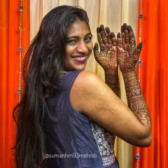 Another joyful pose showcasing the full bridal henna. You can see the detailed work on the palms, which includes traditional motifs that are central to a wedding celebration.